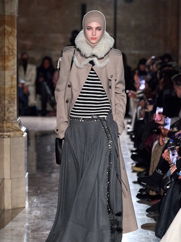 A model wearing a striped sweater, jacket, and long gray skirt from Altuzarra